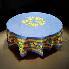 Provence coated cotton round tablecloth in blue with yellow lemon motif, green leaves, and lemon blossoms by Tissus Toselli.