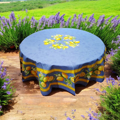 Provence coated cotton round tablecloth in blue with yellow lemon motif, green leaves, and lemon blossoms by Tissus Toselli.