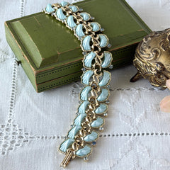 Vintage Leru light blue thermoset Lucite shell bracelet with gold‑tone links and blue rhinestones, signed Leru ©.