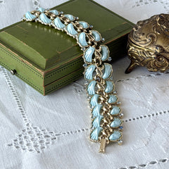 Vintage Leru light blue thermoset Lucite shell bracelet with gold‑tone links and blue rhinestones, signed Leru ©.