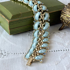 Vintage Leru light blue thermoset Lucite shell bracelet with gold‑tone links and blue rhinestones, signed Leru ©.