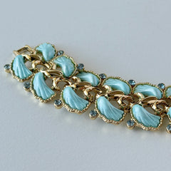 Vintage Leru light blue thermoset Lucite shell bracelet with gold‑tone links and blue rhinestones, signed Leru ©.
