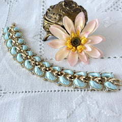 Vintage Leru light blue thermoset Lucite shell bracelet with gold‑tone links and blue rhinestones, signed Leru ©.