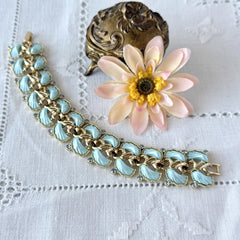 Vintage Leru light blue thermoset Lucite shell bracelet with gold‑tone links and blue rhinestones, signed Leru ©.