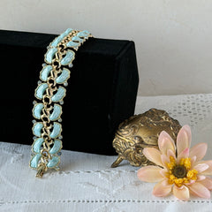 Vintage Leru light blue thermoset Lucite shell bracelet with gold‑tone links and blue rhinestones, signed Leru ©.