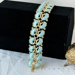 Vintage Leru light blue thermoset Lucite shell bracelet with gold‑tone links and blue rhinestones, signed Leru ©.
