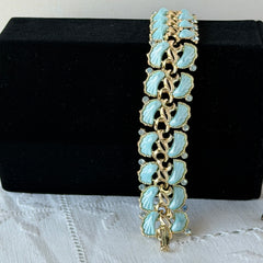 Vintage Leru light blue thermoset Lucite shell bracelet with gold‑tone links and blue rhinestones, signed Leru ©.