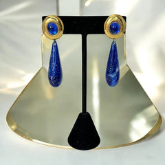 Vintage pierced earrings featuring glossy faux lapis long teardrop pendants and round blue cabochons set in gold-tone metal; likely acrylic components with cosmic speckled finish, measuring approx. 2¼" long, in very good vintage condition with minor glue visible on one cabochon edge.