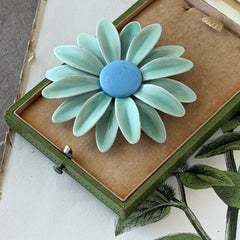Vintage pastel green and blue enamel daisy brooch with layered petals and gold‑tone pin back, circa 1960s.