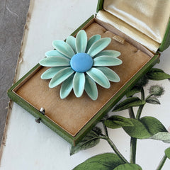 Vintage pastel green and blue enamel daisy brooch with layered petals and gold‑tone pin back, circa 1960s.