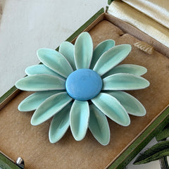 Vintage pastel green and blue enamel daisy brooch with layered petals and gold‑tone pin back, circa 1960s.