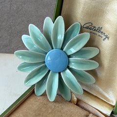 Vintage pastel green and blue enamel daisy brooch with layered petals and gold‑tone pin back, circa 1960s.
