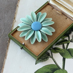 Vintage pastel green and blue enamel daisy brooch with layered petals and gold‑tone pin back, circa 1960s.