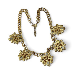 Gold tone statement necklace with five floral pendants featuring peach, champagne, and clear crystals in marquise, square, pear, and chaton cuts; adjustable curb chain with lobster clasp.