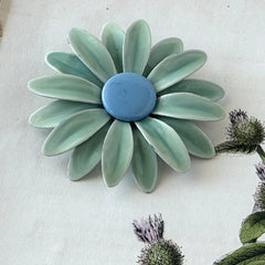 Vintage pastel green and blue enamel daisy brooch with layered petals and gold‑tone pin back, circa 1960s.