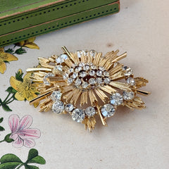 Vintage Lisner gold‑tone sunburst brooch with clear rhinestones, 1960s, signed Lisner ©, excellent condition.