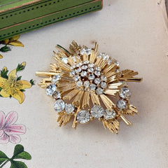 Vintage Lisner gold‑tone sunburst brooch with clear rhinestones, 1960s, signed Lisner ©, excellent condition.