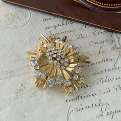 Vintage Lisner gold‑tone sunburst brooch with clear rhinestones, 1960s, signed Lisner ©, excellent condition.
