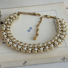 Vintage Lisner necklace with faux pearls and gold‑tone links, shown from various angles to display its mid‑century design, adjustable length, and signed clasp.