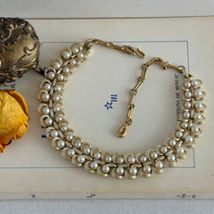 Vintage Lisner necklace with faux pearls and gold‑tone links, shown from various angles to display its mid‑century design, adjustable length, and signed clasp.