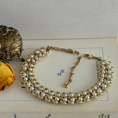 Vintage Lisner necklace with faux pearls and gold‑tone links, shown from various angles to display its mid‑century design, adjustable length, and signed clasp.