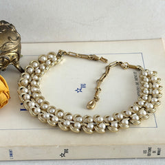Vintage Lisner necklace with faux pearls and gold‑tone links, shown from various angles to display its mid‑century design, adjustable length, and signed clasp.