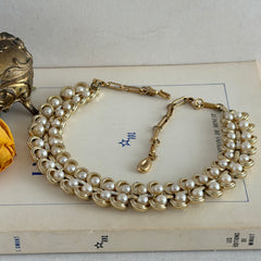 Vintage Lisner necklace with faux pearls and gold‑tone links, shown from various angles to display its mid‑century design, adjustable length, and signed clasp.