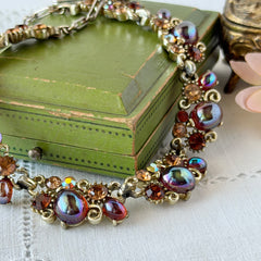 Vintage Lisner iridescent amber glass and topaz rhinestone link necklace with adjustable hook clasp, shown on display and close‑up to highlight its craftsmanship and condition.