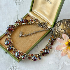 Vintage Lisner iridescent amber glass and topaz rhinestone link necklace with adjustable hook clasp, shown on display and close‑up to highlight its craftsmanship and condition.