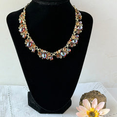 Vintage Lisner iridescent amber glass and topaz rhinestone link necklace with adjustable hook clasp, shown on display and close‑up to highlight its craftsmanship and condition.