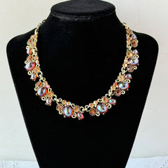 Vintage Lisner iridescent amber glass and topaz rhinestone link necklace with adjustable hook clasp, shown on display and close‑up to highlight its craftsmanship and condition.