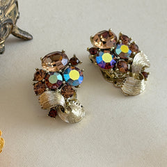 Vintage Lisner light smoked topaz and AB topaz gold‑tone floral clip‑on earrings from the 1950s.
