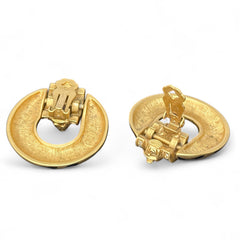 Vintage Elizabeth Taylor for Avon Zebra Stripes clip-on earrings from 1994, featuring bold black enamel and gold-tone door knocker design with sculpted horse and ram head motifs, accented by rhinestones. Signed “Elizabeth Taylor Avon” on the back.