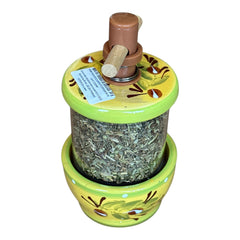 Hand-painted Provence herb mill with green, yellow, and brown olive branch motif on ceramic base, featuring a transparent chamber filled with dried herbs and topped with a wooden handle and cork stoppers.