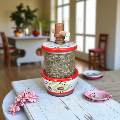 Vintage Provence herb mill with hand-painted olive branch motif in green and black on a cream ceramic base, featuring a ridged interior and terracotta accents.