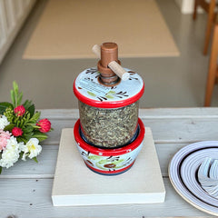 Vintage Provence herb mill with hand-painted olive branch motif in green and black on a cream ceramic base, featuring a ridged interior and terracotta accents.