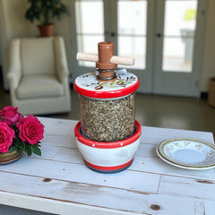 Vintage Provence herb mill with hand-painted olive branch motif in green and black on a cream ceramic base, featuring a ridged interior and terracotta accents.