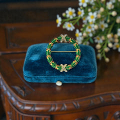 Vintage MMA Fabergé replica Christmas wreath brooch with green guilloché enamel leaves, red berry accents, clear rhinestone ribbon details, and gold‑plated finish; signed MMA © FBS, excellent condition