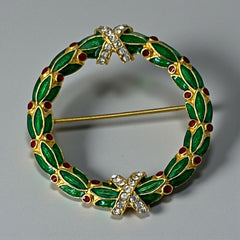 Vintage MMA Fabergé replica Christmas wreath brooch with green guilloché enamel leaves, red berry accents, clear rhinestone ribbon details, and gold‑plated finish; signed MMA © FBS, excellent condition
