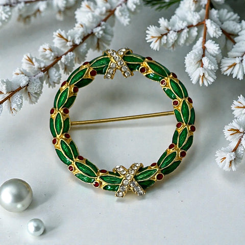 Vintage MMA Fabergé replica Christmas wreath brooch with green guilloché enamel leaves, red berry accents, clear rhinestone ribbon details, and gold‑plated finish; signed MMA © FBS, excellent condition