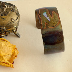 Vintage Southwestern copper and brass cuff bracelet with abalone wolf motif and natural patina, shown from multiple angles.