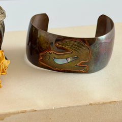 Vintage Southwestern copper and brass cuff bracelet with abalone wolf motif and natural patina, shown from multiple angles.