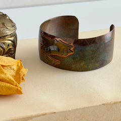 Vintage Southwestern copper and brass cuff bracelet with abalone wolf motif and natural patina, shown from multiple angles.