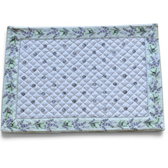 Reversible quilted cotton placemat in Lauris Light Green by Marat d’Avignon, featuring a white center with lavender purple floral medallions and a border of lavender sprigs and olive branches, with a white reverse side  scattered with tiny lavender  blossoms, crafted in Provence.