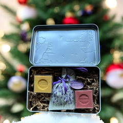 French holiday tin gift box with two mini Marseille soaps and a lavender sachet nestled in crinkle paper, available in Paris, Nice, or Côte d’Azur designs — a festive surprise gift from France.