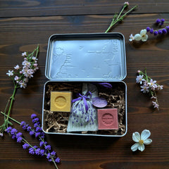 French holiday tin gift box with two mini Marseille soaps and a lavender sachet nestled in crinkle paper, available in Paris, Nice, or Côte d’Azur designs — a festive surprise gift from France.