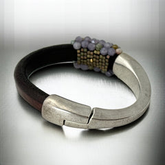 Brown leather and silver-tone half cuff bracelet with magnetic clasp, hand-stitched faceted purple and green amethyst beads, featuring a signature gold accent bead; size 6.