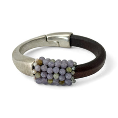 Brown leather and silver-tone half cuff bracelet with magnetic clasp, hand-stitched faceted purple and green amethyst beads, featuring a signature gold accent bead; size 6.