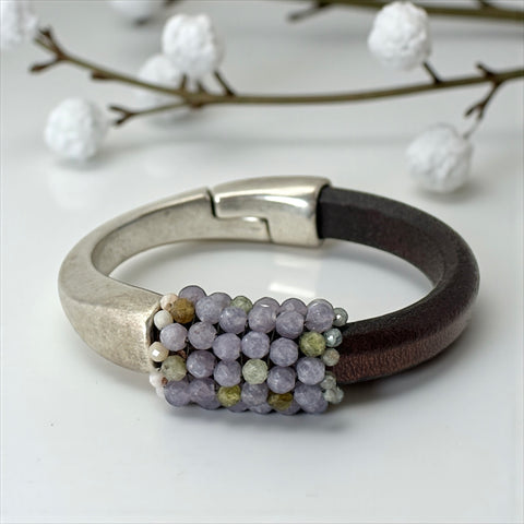 Brown leather and silver-tone half cuff bracelet with magnetic clasp, hand-stitched faceted purple and green amethyst beads, featuring a signature gold accent bead; size 6.