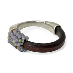 Brown leather and silver-tone half cuff bracelet with magnetic clasp, hand-stitched faceted purple and green amethyst beads, featuring a signature gold accent bead; size 6.